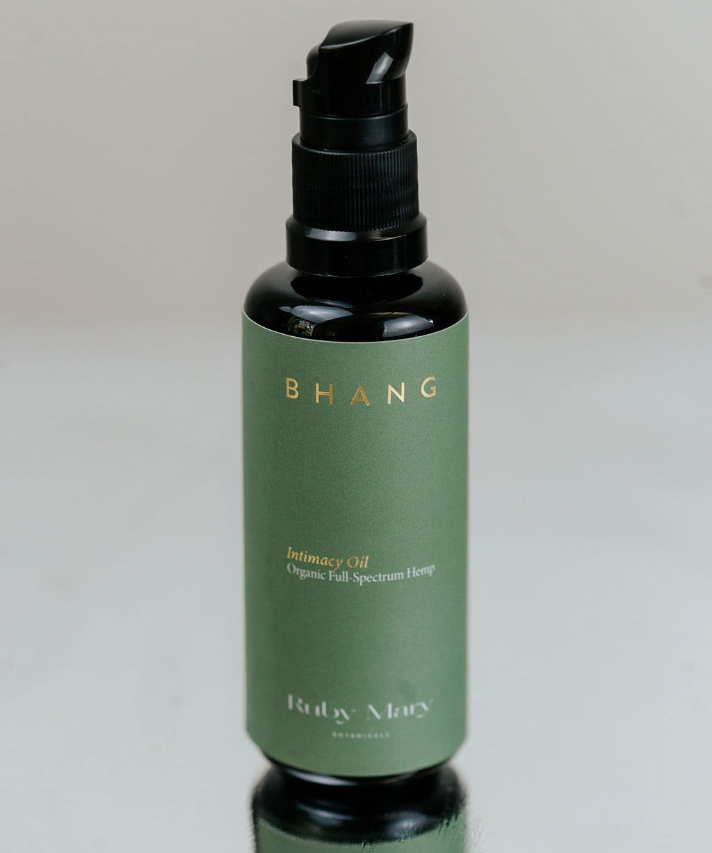 Green bottle with black cap on a reflective surface