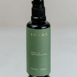 Green bottle with black cap on a reflective surface